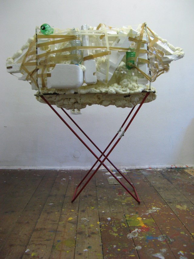 © Wilhelm Roseneder. Offene Erweiterung/Open expansion, 2009. Polyurethan, Klebeband, Styropor, Verpackungsmaterial, Plastikflaschen auf gefundenen Wäschetrockner/Polyurethane, sticky tape, styropor, packing material, plastic bottles on found clothes-dryer.