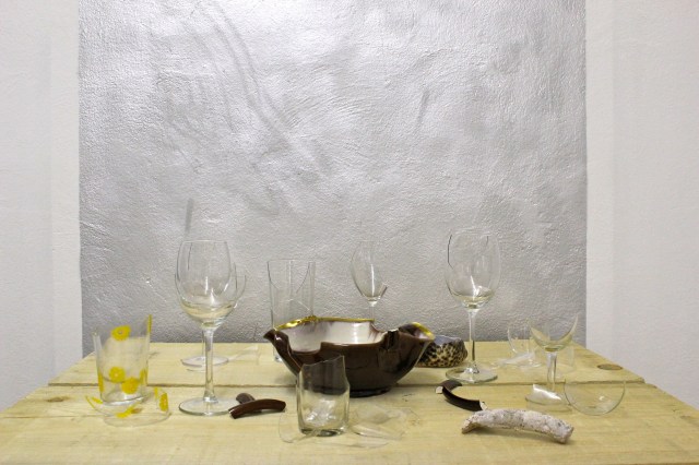 © Renate Egger. Zerbrochene Erinnerungen/Broken memories, 2012. Installation, Fotografie. Gläser, Porzellan, römisches antikes Fragment , Muschel aus Zanzibar auf Holzpaletten/ Installation, photography. Glasses, porcelain, roman antique fragment, shell from Zanzibar on wooden palletts