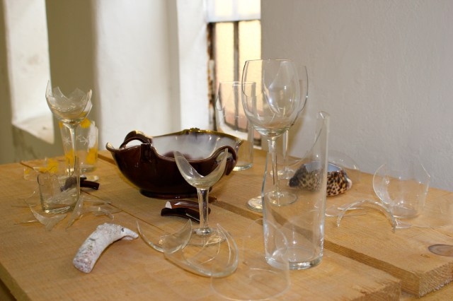 © Renate Egger. Zerbrochene Erinnerungen/Broken memories, 2012. Installation, Fotografie. Gläser, Porzellan, römisches antikes Fragment , Muschel aus Zanzibar auf Holzpaletten/ Installation, photography. Glasses, porcelain, roman antique fragment, shell from Zanzibar on wooden pallets