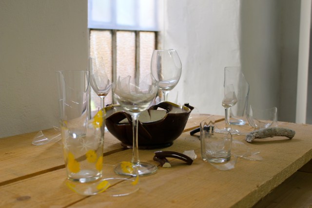 © Renate Egger. Zerbrochene Erinnerungen/Broken memories, 2012. Installation, Fotografie. Gläser, Porzellan, römisches antikes Fragment , Muschel aus Zanzibar auf Holzpaletten/ Installation, photography. Glasses, porcelain, roman antique fragment, shell from Zanzibar on wooden pallets